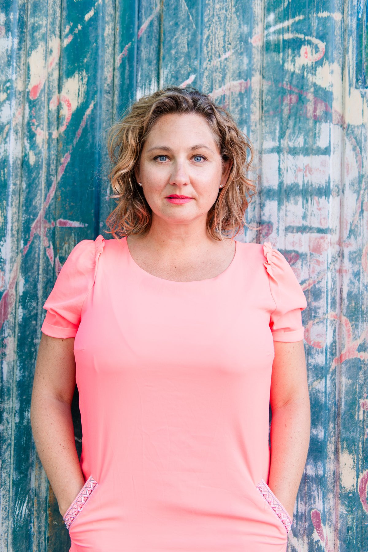 Natalie, RTT specialist and hypnotherapist, standing confidently in a pink dress